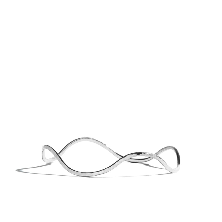 A stylish twisty hand-hammered bangle crafted from sterling silver, perfect for adding a touch of flair to any outfit. Perfect for stacking your pieces.