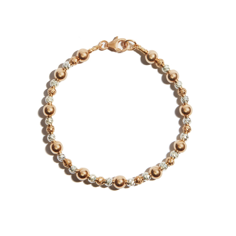 A stylish two-tone bracelet featuring alternating beads made of 14ct gold fill and sterling silver, with larger beads adding extra flair.