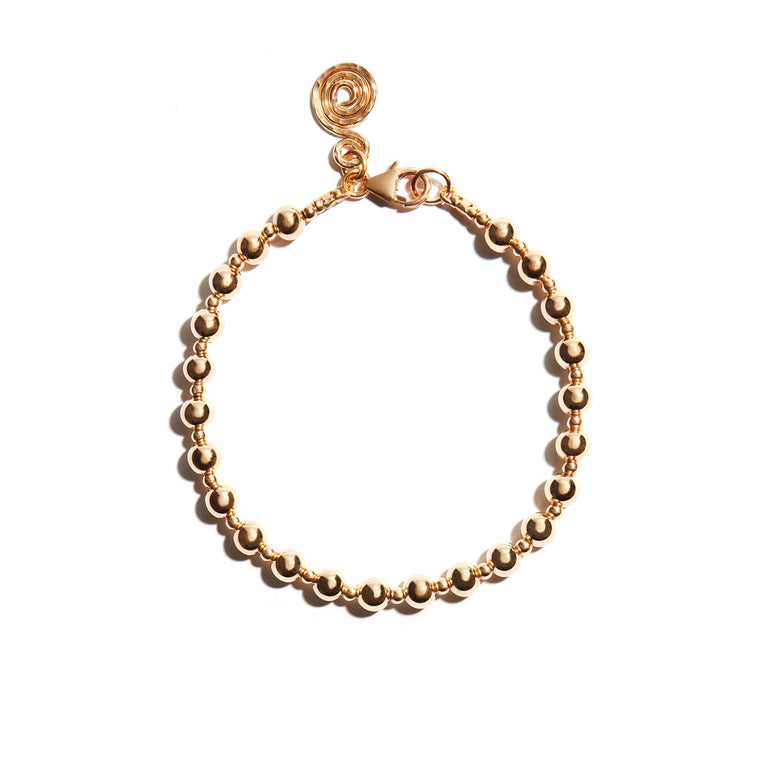 Photo of our Stackable Gold Bracelet features large and small consecutive strung beads, complete with a Seoidín Celtic spiral at the clasp. A much loved feature of Seoidín designs, the celtic spiral pays homage to Ireland, our infinite inspiration.