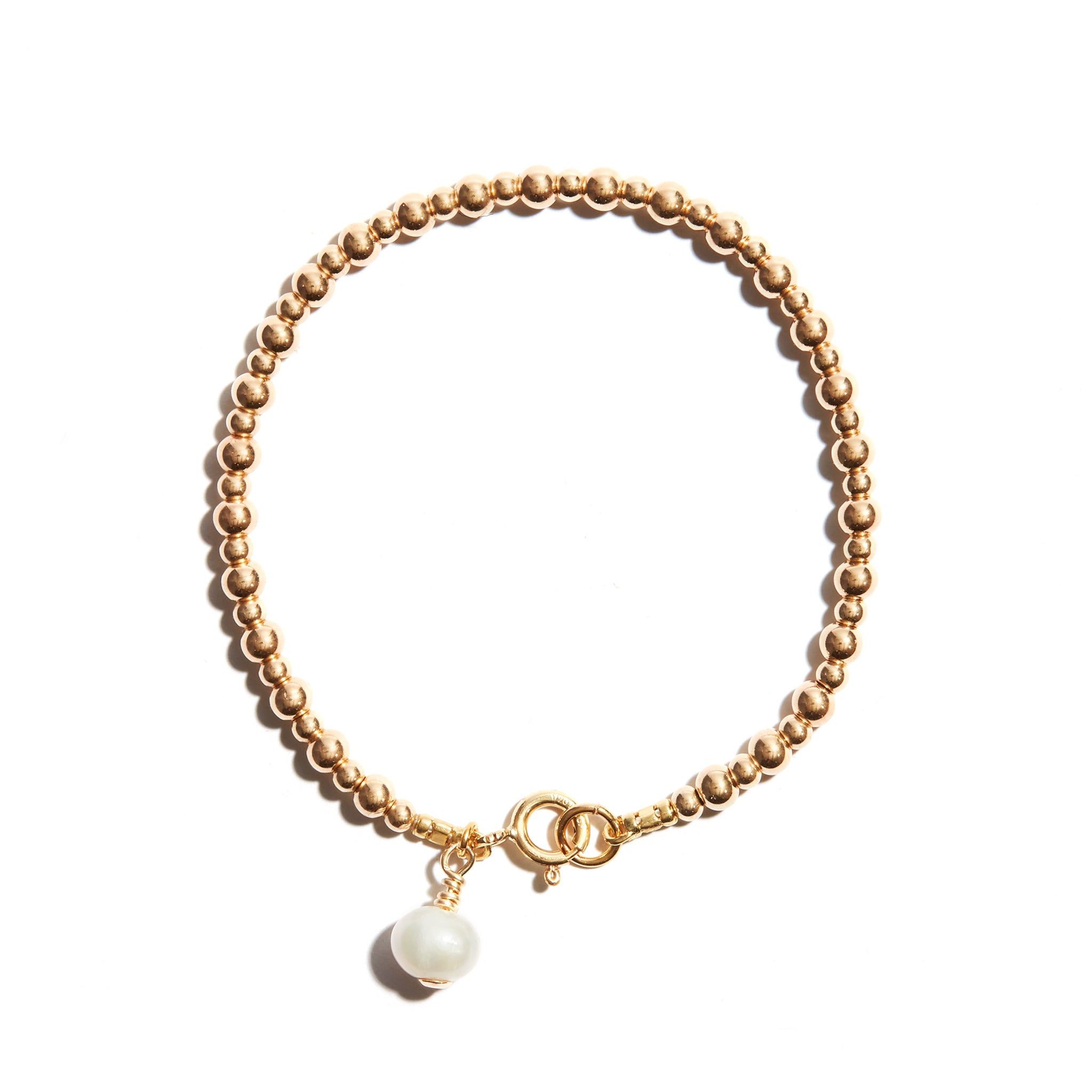 Photo of our Pearl Charm Stacking Bracelet features larger followed by smaller beads consecutively strung, and a single pearl charm at the clasp to add just a little extra bit of elegance.