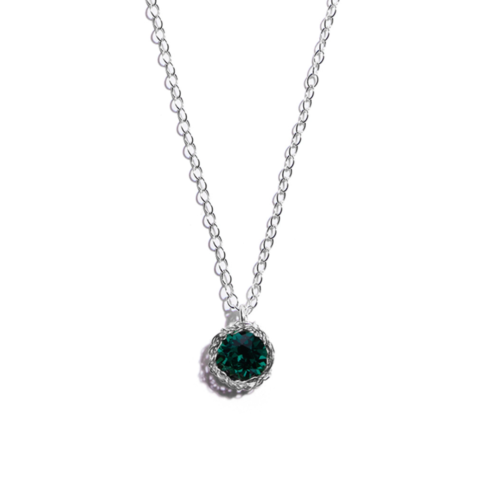Close-up photo of a crochet necklace featuring a May birthstone pendant made of emerald, set in sterling silver.