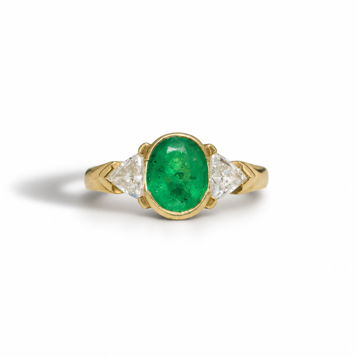 This exquisite three stone ring showcases a vibrant 1.20ct emerald as its captivating centerpiece. Crafted in luxurious 18ct yellow gold weighing 3.84 grams, the warm golden hue beautifully enhances the emerald's rich green color. The classic three stone design creates a timeless silhouette that highlights the natural beauty of the emerald. This sophisticated piece combines elegant craftsmanship with the alluring charm of one of nature's most coveted gemstones, making it a striking addition to any fine jewe