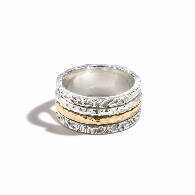 A stack of three textured rings, featuring two silver rings with floral engravings and one central gold ring, displayed on a clean white background.