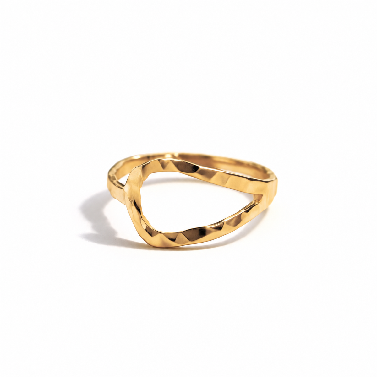 A gold ring with a hammered texture and an organic, wavy triangular shape, photographed on a clean white background with a soft shadow.