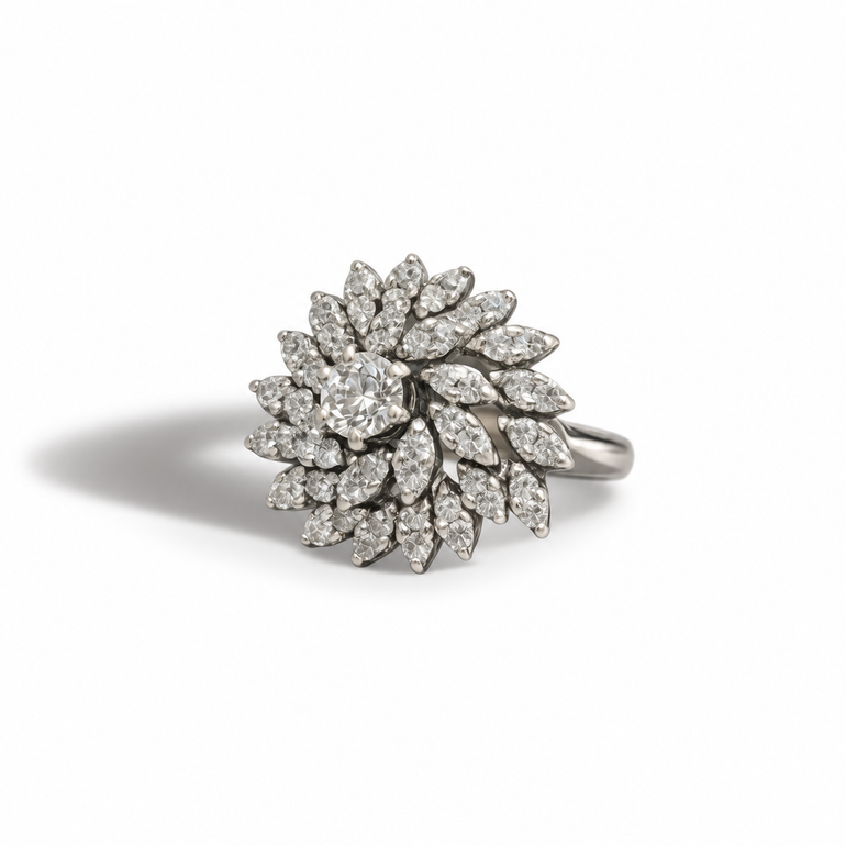 A bold vintage cluster ring designed to catch the light from every angle.

Crafted in 14ct white gold, this statement piece features a central round diamond, surrounded by an intricate arrangement of round-cut diamonds, creating a layered, floral-inspired cluster with beautiful movement and sparkle.

The elevated, sculptural setting gives the ring volume and presence, making it a true cocktail piece — dramatic, feminine, and unmistakably vintage.

A standout addition to any collection, perfect for occasions