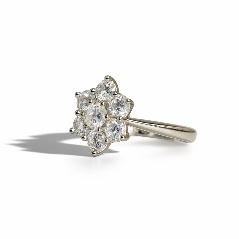 Vintage white gold diamond cluster ring featuring a central round brilliant diamond surrounded by six round diamonds in a floral setting.