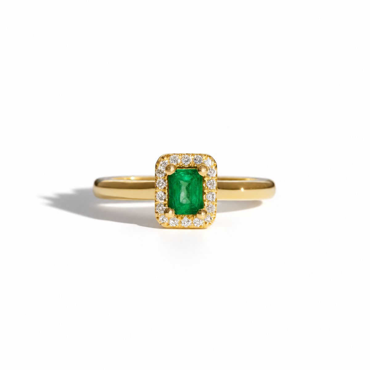 Yellow gold emerald and diamond halo ring with rectangular emerald-cut green gemstone