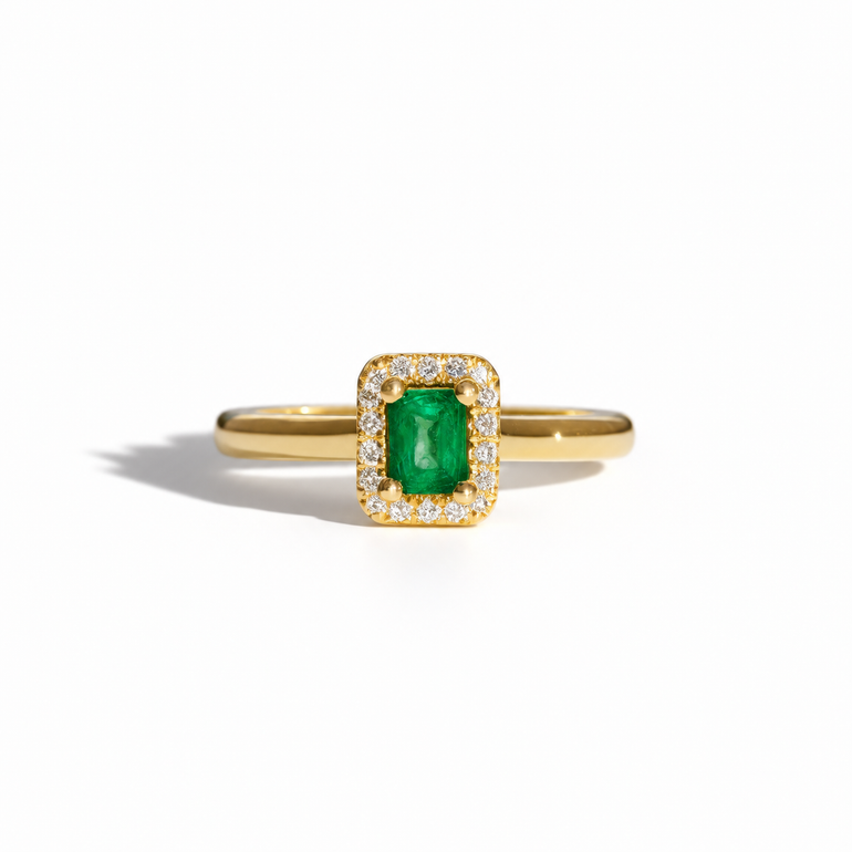 Yellow gold emerald and diamond halo ring with rectangular emerald-cut green gemstone