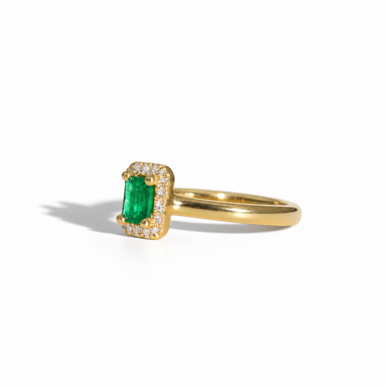 Yellow gold emerald and diamond halo ring with rectangular emerald-cut green gemstone