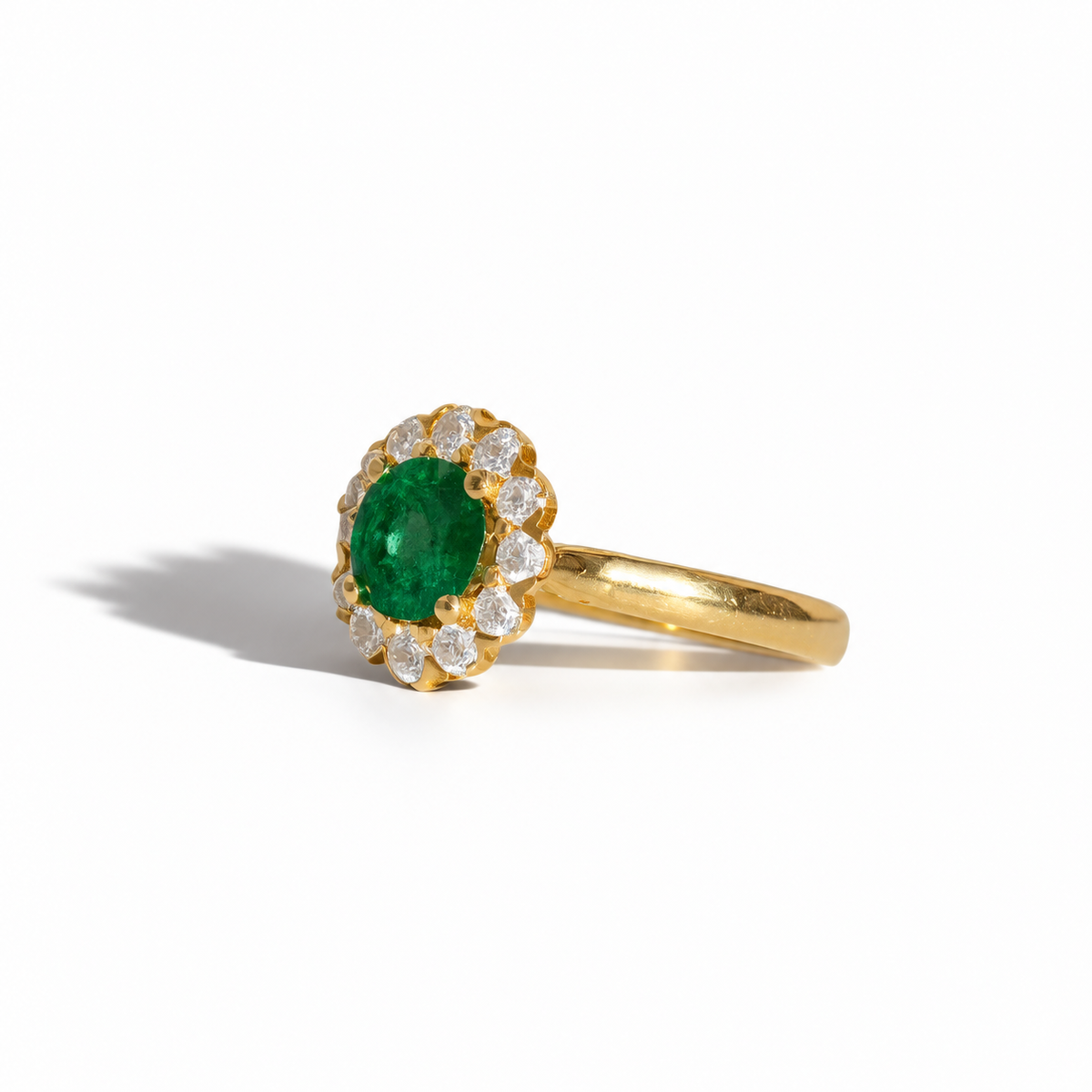 Yellow gold emerald and diamond halo ring with round green emerald centre stone and brilliant-cut diamond surround