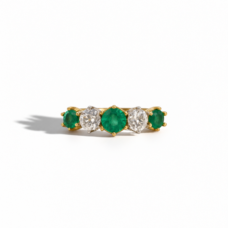 Yellow gold five-stone emerald and diamond ring featuring three round emeralds and two round brilliant-cut diamonds