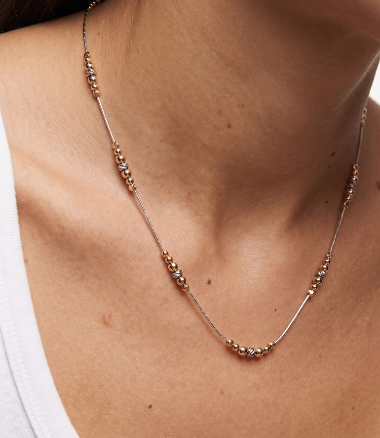 Necklace with small beads on a person's neck
