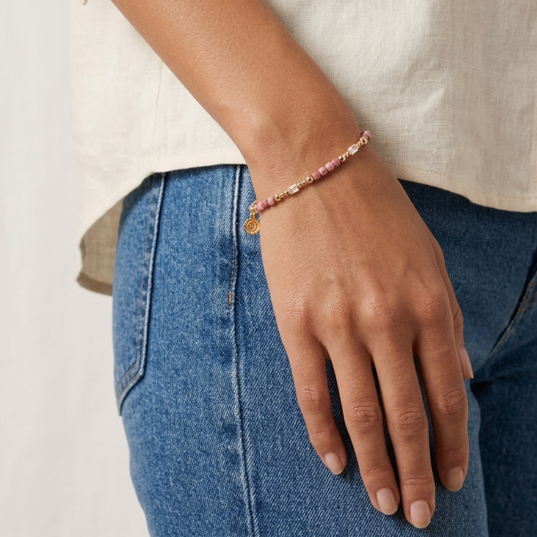 Person wearing a bracelet on a plain background