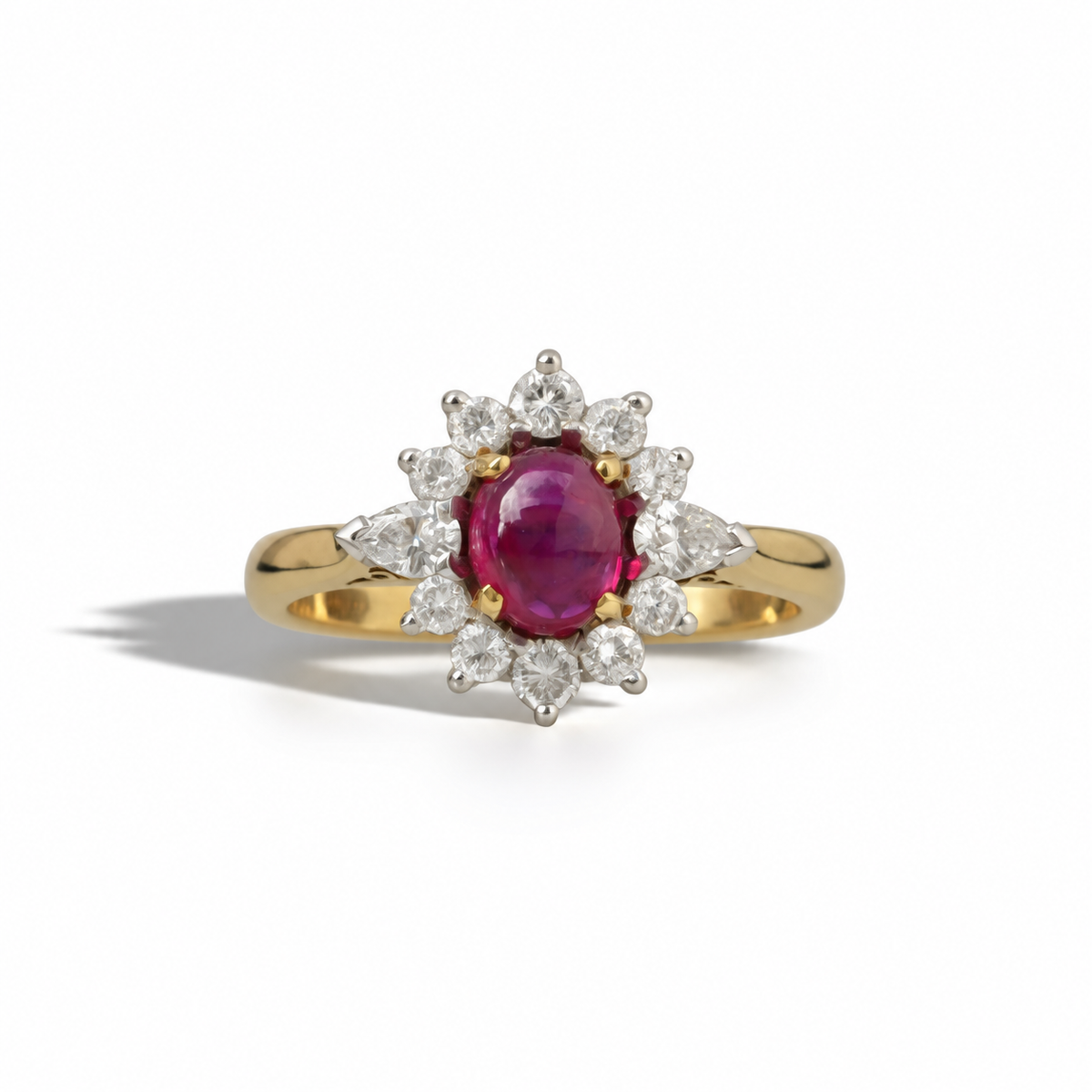 Alt text: Vintage yellow gold ring featuring an oval deep pink ruby surrounded by a floral halo of round and pear-shaped diamonds.