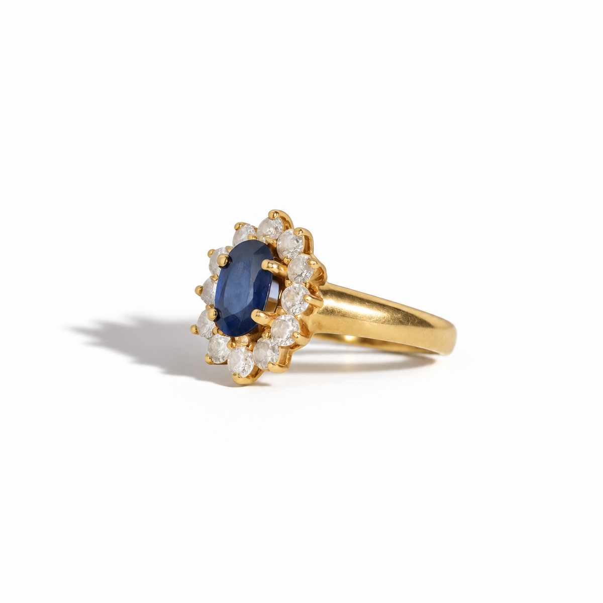 Vintage yellow gold oval blue sapphire and diamond halo ring with round brilliant cut diamonds
