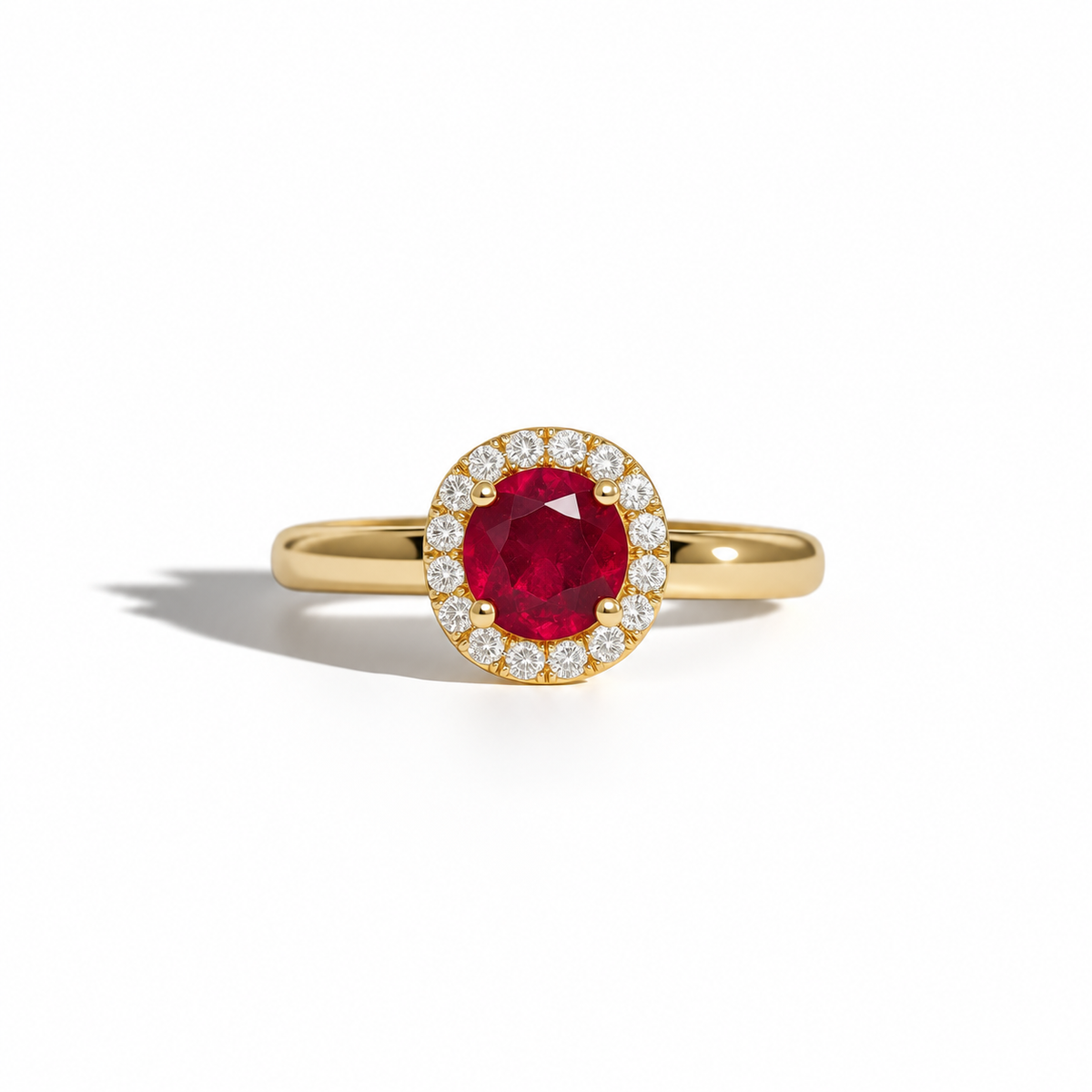 Yellow gold ruby and diamond halo ring featuring a round-cut red ruby centre stone surrounded by brilliant-cut diamonds.