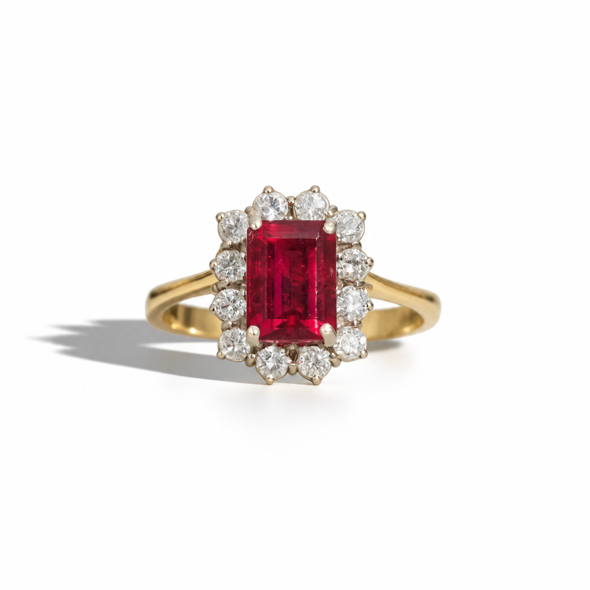 Vintage yellow gold ring featuring a rectangular emerald-cut red gemstone surrounded by a halo of round diamonds