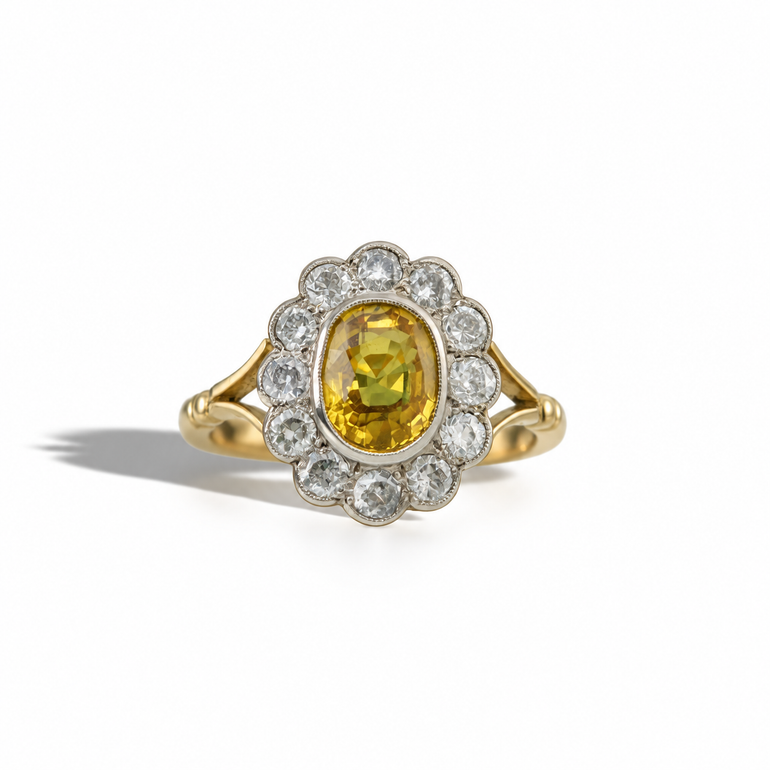 Vintage yellow gold ring with an oval golden-yellow gemstone, surrounded by a scalloped halo of round diamonds in a white metal setting.