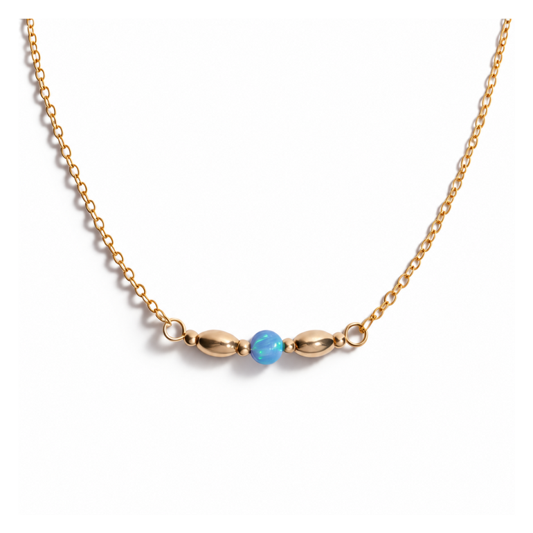 A delicate gold chain necklace featuring a central bar with two elongated gold beads flanking a small, round light blue bead, shown against a plain white background.