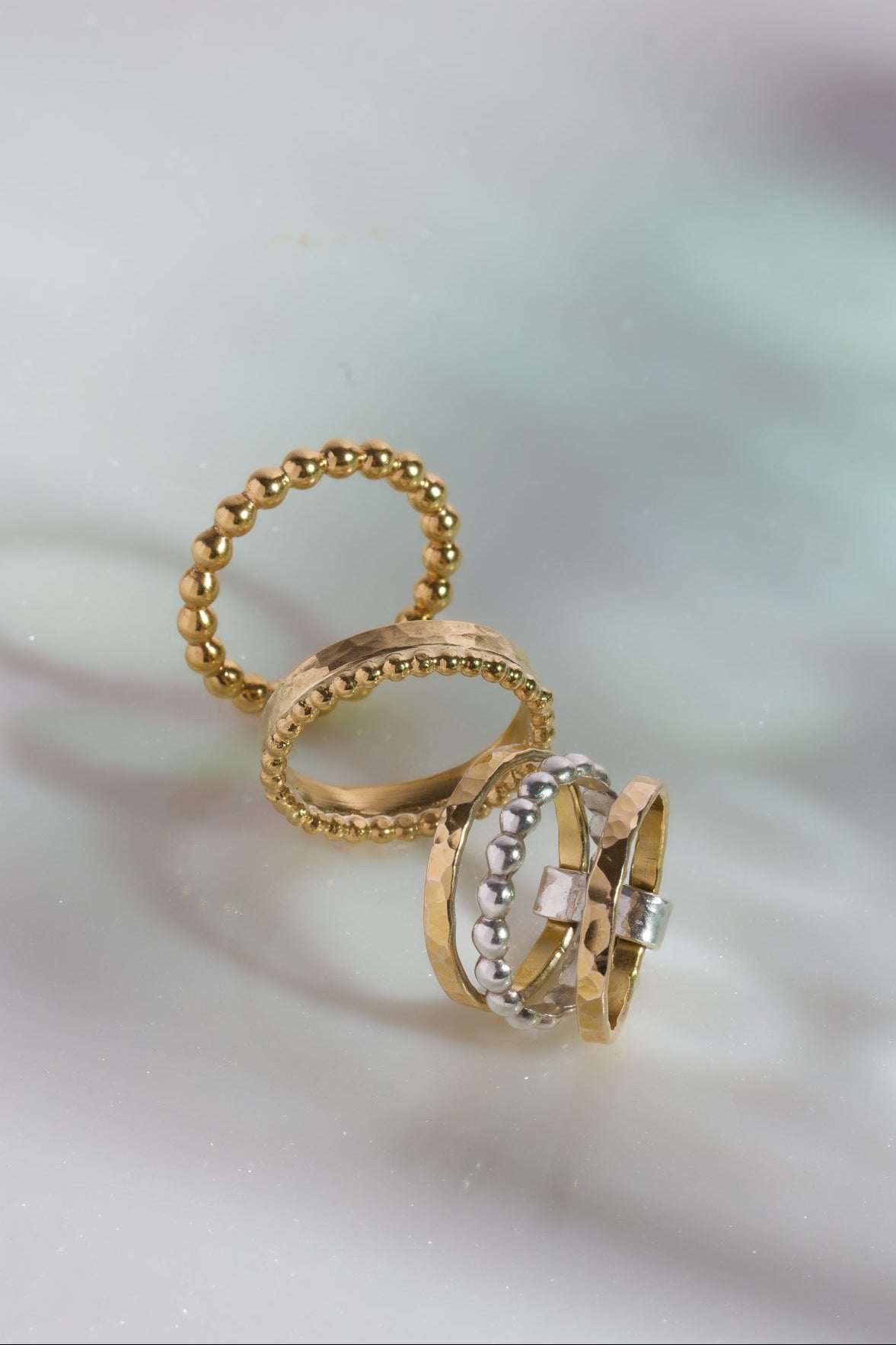 Gold ring with a textured band on a soft, blurred background
