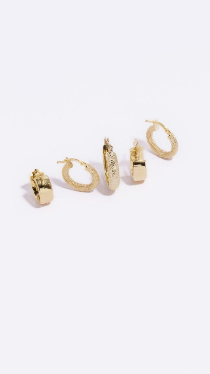 Set of gold hoop earrings on a white background