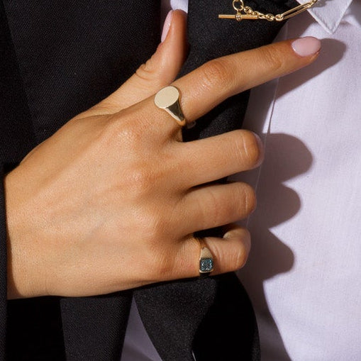 Person wearing a black suit jacket over a white shirt with a plain background