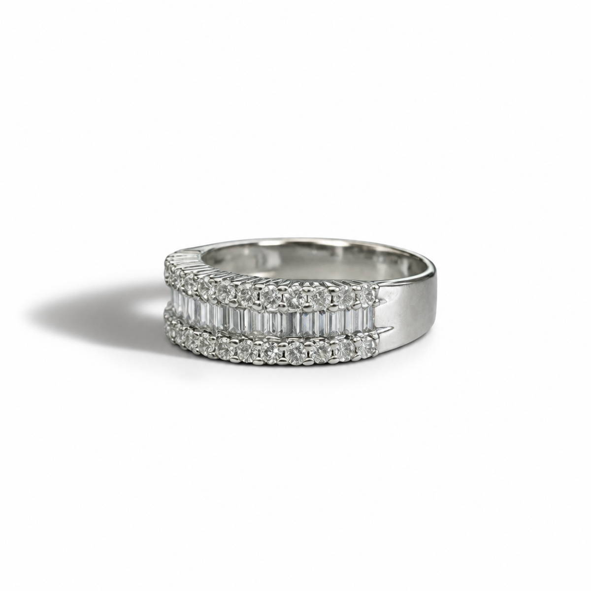 A sleek vintage diamond band with a refined, structured design that balances brilliance and symmetry beautifully.

Crafted in 14k white gold, this ring features a central row of baguette-cut diamonds, framed by two rows of round brilliant diamonds for added sparkle and depth. The layered effect creates a bold yet elegant silhouette, making it perfect as a statement band, stacking piece, or alternative wedding ring.

Understated but striking — this is effortless everyday luxury.

Key Details

14k White Gold
