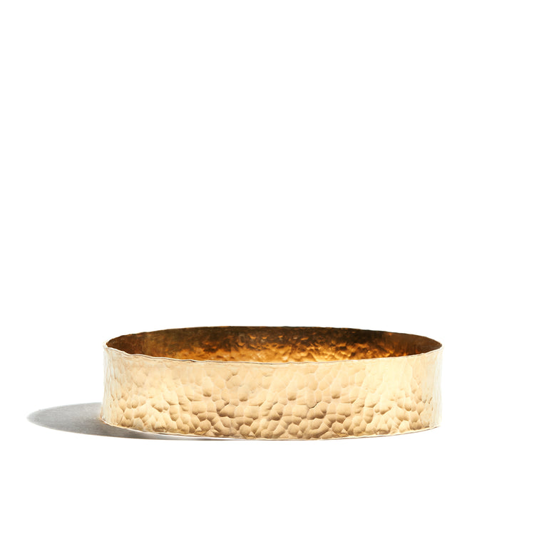 A chunky hand-hammered gold bangle made from 14ct gold fill, ideal for adding a touch of luxury to your wrist.