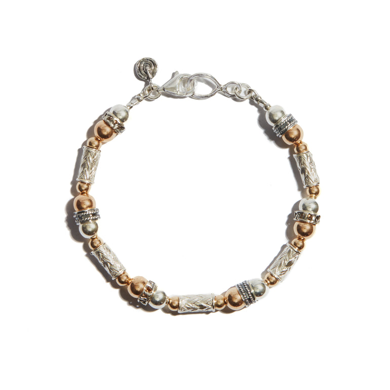 A trendy Two Tone Hammered Bracelet with beads made of 14ct gold fill and sterling silver, showcasing detailed silver bars make this pice the perfect gift to someone special.