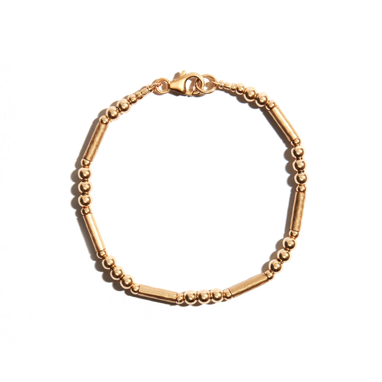 Photo of our Simple Gold Bracelet features consecutively strung beads and textured tube beads to create a delicate & simple gold bracelet that everyone will love.