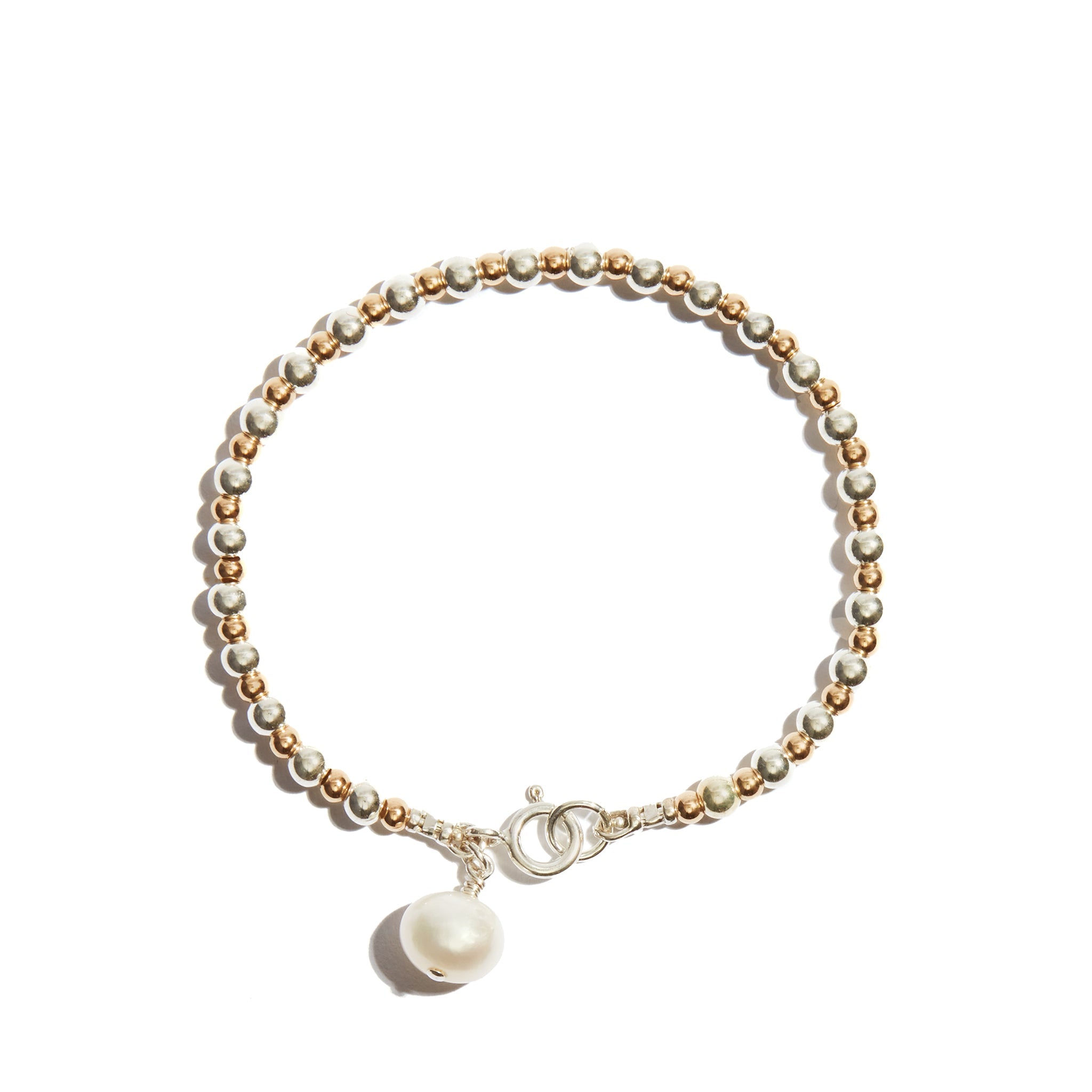 Our Pearl Charm Stacking Bracelet features larger followed by smaller beads consecutively strung, and a single pearl charm at the clasp to add just a little extra bit of elegance.