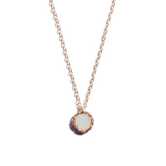 Close-up photo of a crochet necklace featuring a October birthstone pendant made of opal, set in 14 ct gold-filled metal.