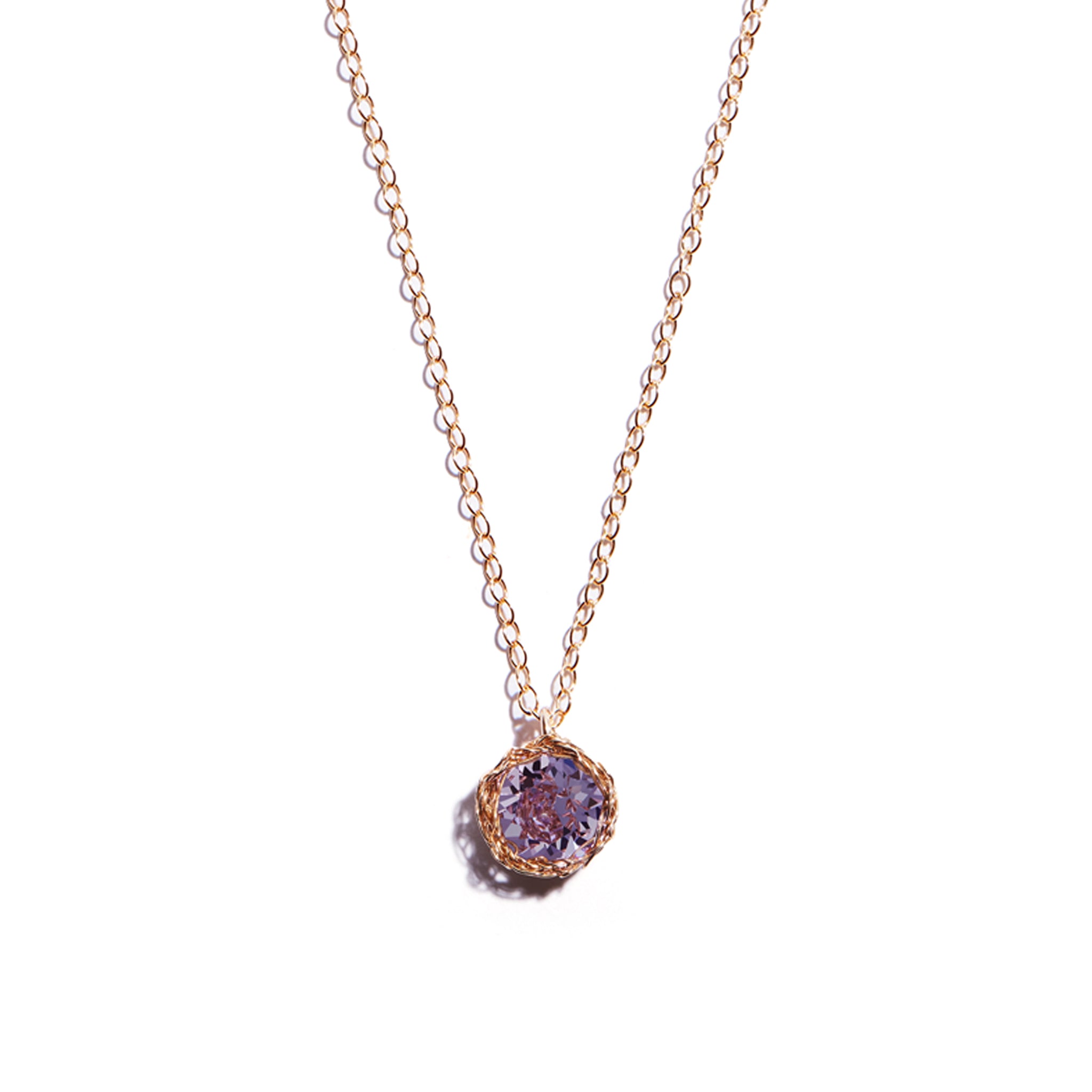 Close-up photo of a crochet necklace featuring a February birthstone pendant made of amethyst, set in 14 ct gold-filled metal.