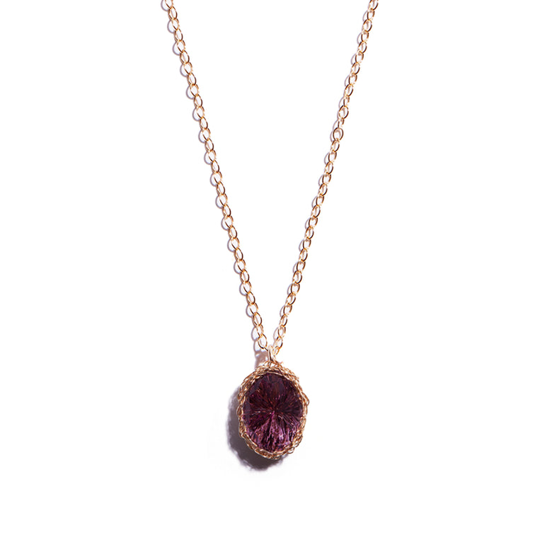 Close-up photo of an amethyst oval pendant, beautifully crafted from 14 carat gold-filled material. This stunning accessory exudes elegance  and adds a touch of luxury to any outfit.