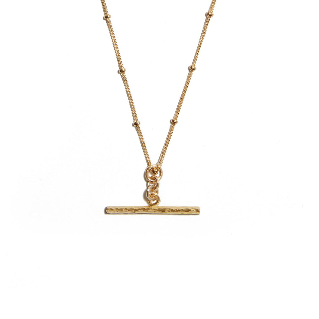 Enhance your style with the T-Bar on cut ball chain necklace made from 14ct Gold-fill. This chic accessory features a sleek T-Bar pendant suspended from a stylish cut ball chain, perfect for adding a touch of sophistication to any outfit. A versatile piece for everyday wear.