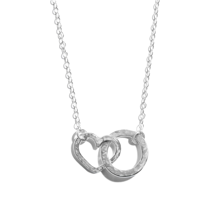 Photo of a small interlinking heart and circle necklace made from sterling silver. A charming accesory ideal for gifting or adding a touch of elegance to any outfit.